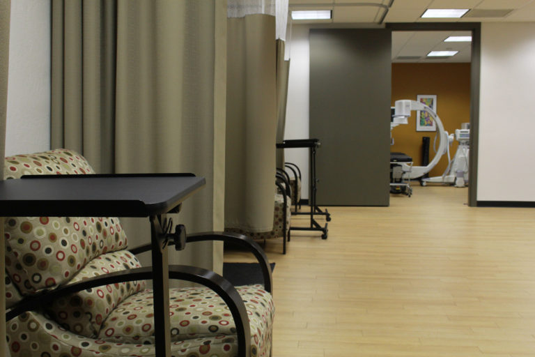 room with multiple curtained sections with chairs